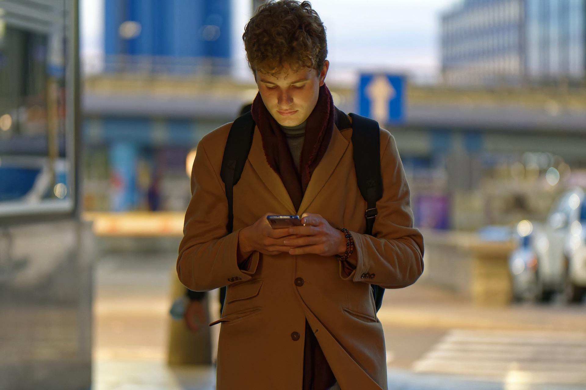En ung mand der kigger på sin mobiltelefon